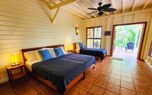 a bedroom with a bed and a couch and a fan at Bluff Beach Retreat in Bocas del Toro +73 photos