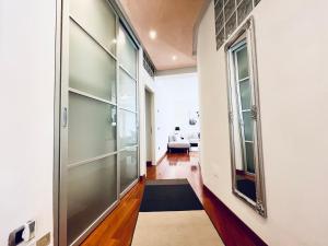 Un pasillo con una gran puerta de cristal y un espejo. en Appartamento villatorretta24, en Riva del Garda 50 fotos más