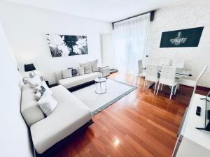 Una sala de estar con un sofá blanco y una mesa. en Appartamento villatorretta24, en Riva del Garda