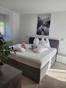 ein Schlafzimmer mit einem Bett mit weißen Laken und Kissen in der Unterkunft Apartament Zaharia in Tumpen