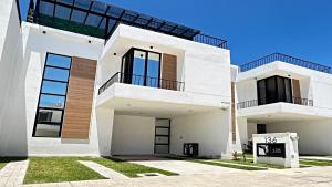 a white house with two balconies on it at Brand New Cow House Aldea Hortus 136 by Kivoya in Naranjo