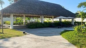 a pavilion with chairs and tables and a straw roof at Brand New Cow House Aldea Hortus 136 by Kivoya in Naranjo