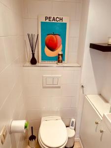 un baño con aseo y una foto de una manzana en Antwerp City Nest, en Amberes