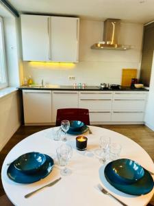 una mesa con dos platos azules y vasos en ella en Antwerp City Nest, en Amberes