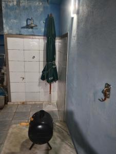 a green umbrella in a corner of a bathroom at Casa do Flávio e João Paulo in Belo Horizonte