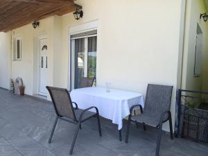 a table with two chairs and a white table cloth at Trikala Groundhouse in Rizareión +14 photos
