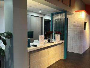 baño con encimera con ordenador en ibis Budget Mâcon Sud, en Mâcon