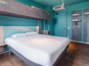 a large bed in a room with blue walls at ibis Budget Mâcon Sud in Mâcon +32 photos