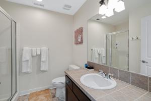 a bathroom with a sink and a toilet and a mirror at Charming Hillsboro Condo with Pool and Gym in Hillsboro +11 photos