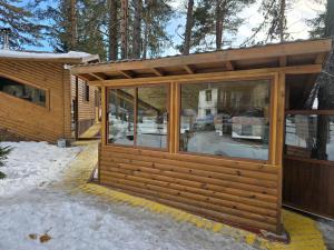 eine Holzhütte mit Glasfenstern im Schnee in der Unterkunft Villa Margarita 1 in Belitsa