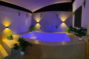 a purple bathroom with a tub with potted plants at Sáasil Retreat - Connect with yourself in Mérida