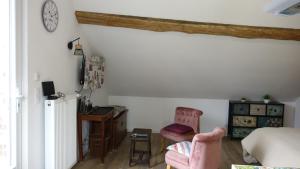 a bedroom with a bed and a desk and a chair at La Maréchalerie, studio authentique au cœur d'un beau village Gâtinais 