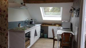 a small kitchen with a sink and a stove at La Maréchalerie, studio authentique au cœur d'un beau village Gâtinais 