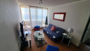 a living room with a blue couch and a table at Vacaciones frente al Mar in Valparaíso
