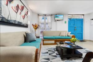 a living room with two couches and a blue door at Casa Mary Hotel in Cartagena de Indias