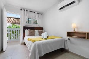 a bedroom with a bed with a yellow blanket at Casa Mary Hotel in Cartagena de Indias +40 photos