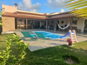 a house with a swimming pool with a swing at RECANTO dos SONHOS - MASSARANDUPIÓ - SUÍTES & QUARTOS in Massarandupio