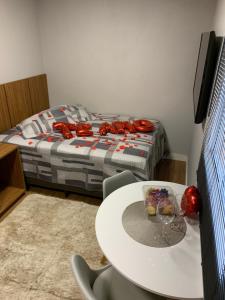 a room with a table and a bed with glasses on it at Microcasa na cobertura in Santa Teresa