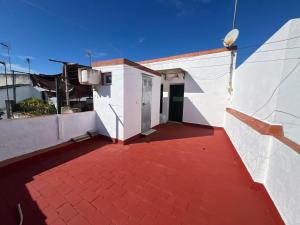 un edificio con suelo rojo y techo rojo en Villa Hogar Espartinas, en Espartinas