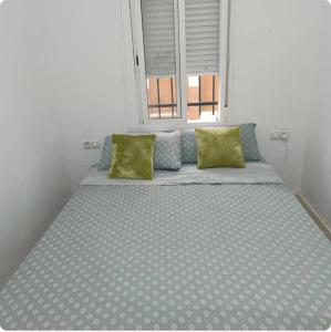una cama grande en una habitación con ventana en Villa Hogar Espartinas, en Espartinas
