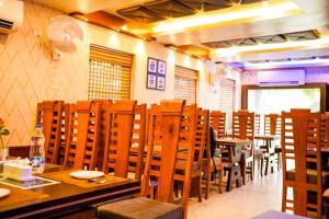 a dining room with wooden tables and chairs at Hotel O Blue Diamond Hotel And Restaurant in Hugli +36 photos