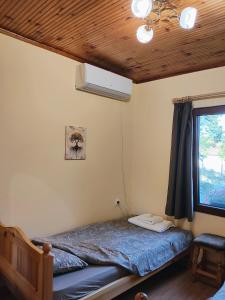 una camera da letto con un letto e una finestra di Вила Хармония Harmony Cottage a Zhilentsi