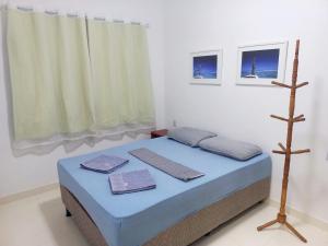a bedroom with a bed with blue sheets and towels at QUARTO PRIVATIVO - RECANTO dos SONHOS - MASSARANDUPIÓ in Massarandupio +23 photos