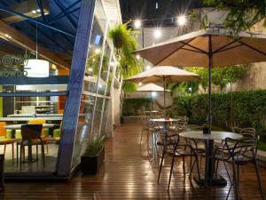 a patio with tables and chairs with umbrellas at ibis budget Sao Paulo Paraiso in Sao Paulo