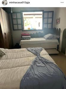 グアルジャにあるCasinha da Lollaの窓のある部屋にベッドが2つある