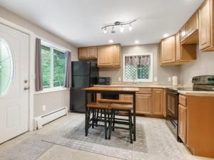 eine Küche mit Holzschränken und einem Tisch und Stühlen in der Unterkunft Cozy 2BR Mountain Retreat Near Killington Resort - Pet Friendly, Fireplace, Foosball in Sherburne Center + 8 Fotos