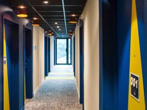 an empty hallway with blue and yellow walls at ibis budget Reims Thillois in Reims