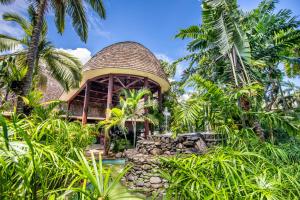 a resort with a pool and a building with palm trees at Tanoa Tusitala Hotel in Apia