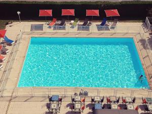 an overhead view of a large swimming pool with chairs at ibis Budget Arles Palais Des Congres in Arles