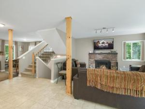 ein Wohnzimmer mit Kamin und Treppe in der Unterkunft Cozy 3BR Retreat Near Killington Resort - Fireplace, Pet Friendly in Sherburne Center