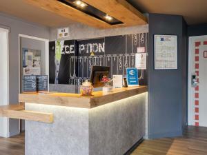 a restaurant with a counter in a room at ibis budget Rennes Chantepie - Hôtel rénové in Chantepie