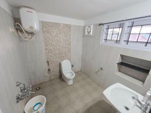 ein Badezimmer mit einer weißen Toilette und einem Waschbecken in der Unterkunft Coffee cottage guest house in Madikeri + 18 Fotos