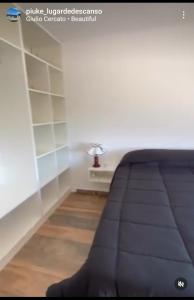 a room with a bed and a table with a lamp at PIUKE lugar de descanso in Tandil