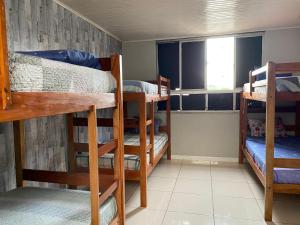 ein Zimmer mit drei Etagenbetten und einem Fenster in der Unterkunft Hostel Recanto dos Viajantes in Belém