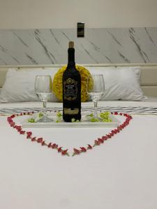 a bottle of wine sitting on a table with two glasses at Appart'hotel avec jacuzzi à Adjarra in Adjarra