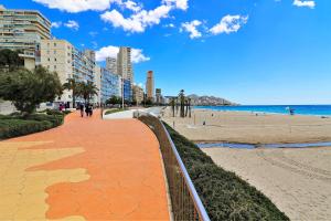 un marciapiede accanto a una spiaggia con edifici e l'oceano di Sunset Waves I by Terreta Rentals a Benidorm