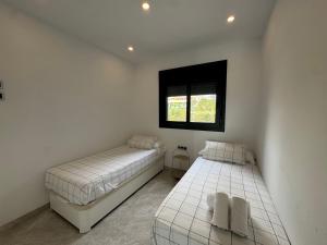 due letti in una stanza bianca con una finestra di Sunset Waves I by Terreta Rentals a Benidorm Altre 26 foto