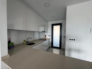 una cucina vuota con armadi bianchi e lavandino di Sunset Waves I by Terreta Rentals a Benidorm