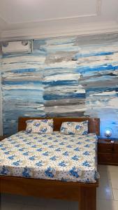 a bedroom with a bed with a blue and white wall at Petit palais in Dakar