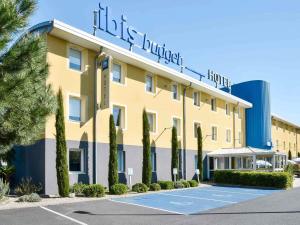un hotel con una pista de tenis delante en ibis budget Issoire, en Issoire