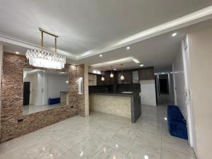 a large kitchen with a chandelier in a room at Central Urdesa, Bálsamos 920 in Guayaquil