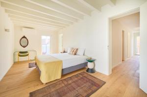 Un dormitorio blanco con una cama y una silla. en Luxury Villa by the Sea w Salty Pool, by TimeCooler, en Oeiras