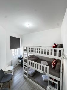 Una habitación con dos literas y un televisor. en 3 Person private room in Zone 2, en Londres