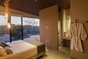 a bedroom with a bed and a large window at Casa Bless - Piribless in Pirenópolis