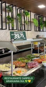 a buffet of food in a restaurant with a sign at Quartos com banheiro compartilhado em Araguaína in Araguaína