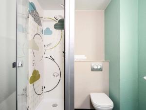 une petite salle de bain avec toilettes et douche dans l'établissement Ibis Budget Lille Gares Vieux-Lille, à Lille 36 autres photos